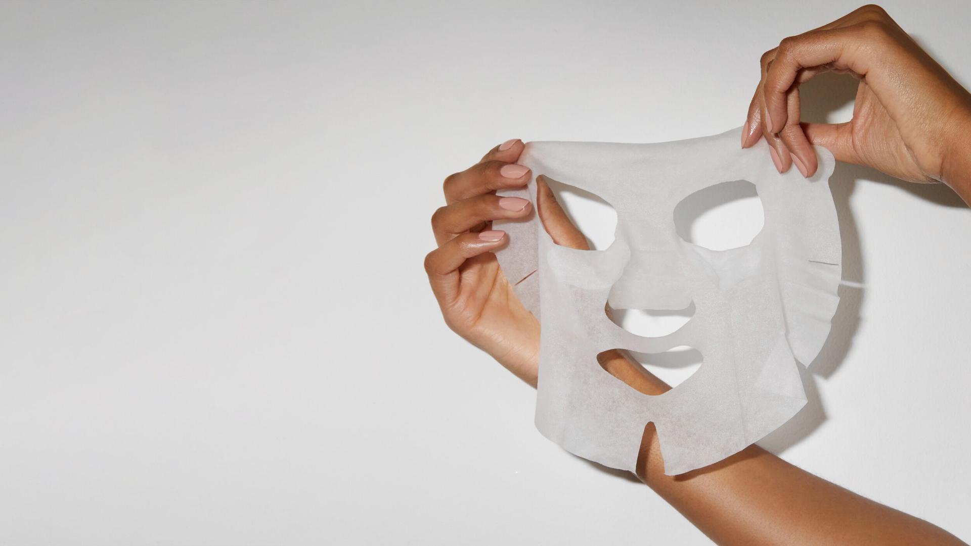 Model holding up a Beauty Pie sheet mask 