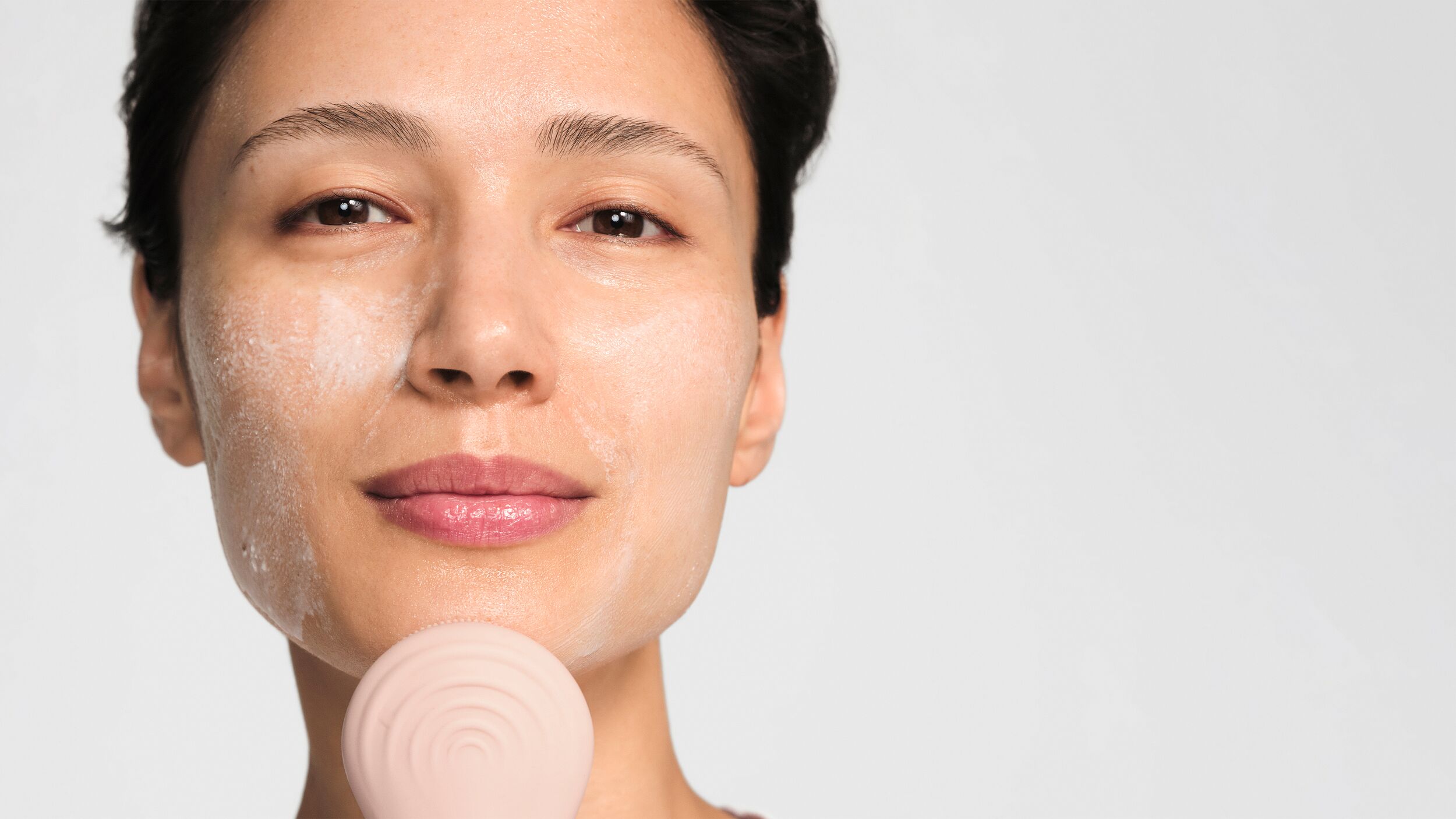 blog-kinetic-cleansing.jpg Model cleansing her skin using the cleansing brush