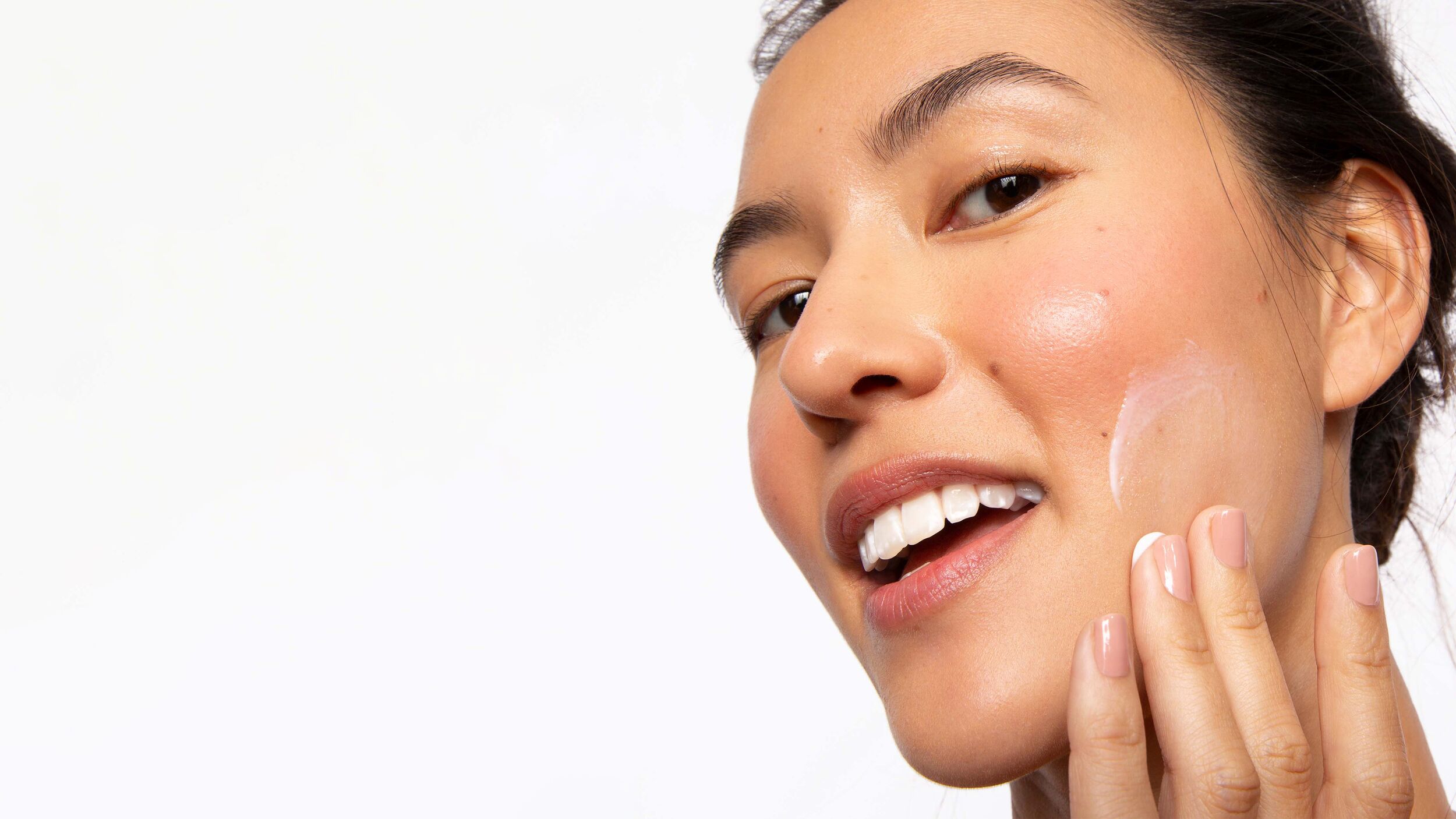 model-applying-skincare.jpg Model applying a cream to her face